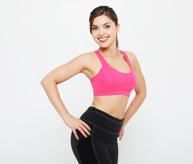 Sport and people concept Cheerful attractive young fitness woman in top and black leggings