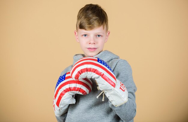 Sport punching knockout Childhood activity Fitness diet energy health workout of small boy boxer Sport success sportswear fashion usa independence day Happy child sportsman in boxing gloves