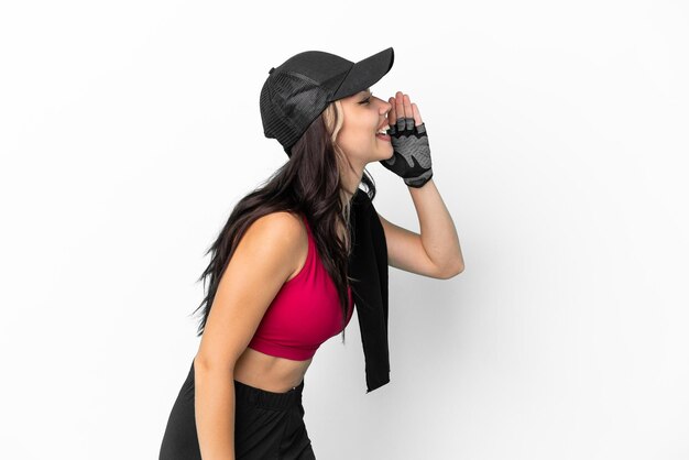 Sport Russian girl with hat and towel isolated on white background shouting with mouth wide open to the lateral