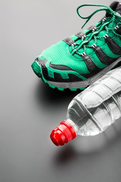 Спортивная обувь и бутылка воды