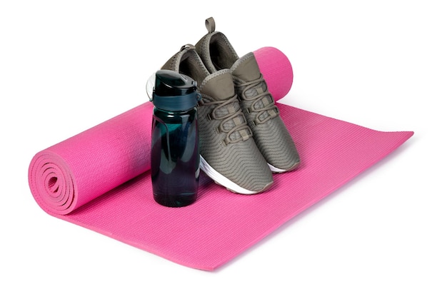 Спортивная обувь и коврик для йоги на белом фоне