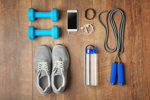 Sport sneakers and equipment on wooden background