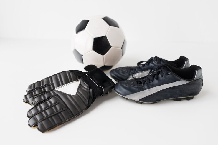 Photo sport, soccer, football and sports equipment concept - close up of ball, boots and goalkeeper gloves over white background