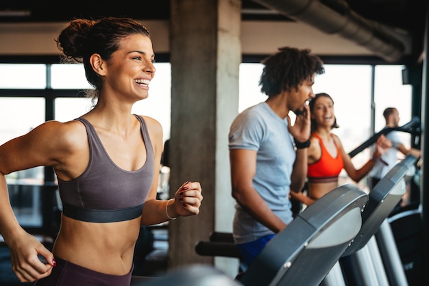 Sport sportschool levensstijl oefening en mensen concept. Gelukkige fitte mensen die trainen in de sportschool