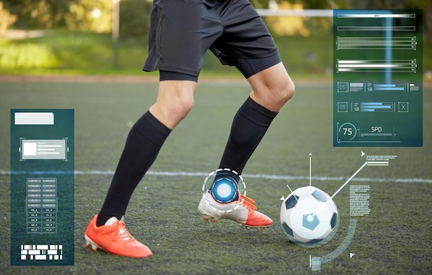 Foto concetto di sport, tecnologia e persone - calciatore che gioca con la palla sul campo di calcio