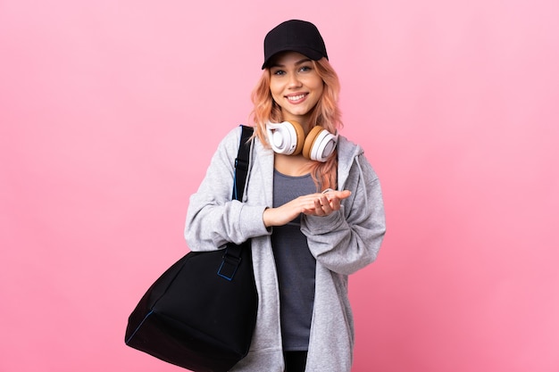 sport teenager girl with sport bag over isolated applauding