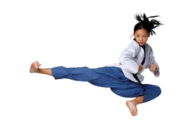 Sport Tienermeisje springt hoog en schopt als zweven in de lucht. 12-15 jaar oud Aziatisch jeugdatleet kind draagt Taekwondo Karata Uniform over witte achtergrond geïsoleerd volledige lengte
