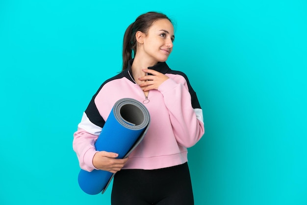 Sport Ukrainian woman going to yoga classes while holding a mat looking up while smiling