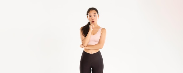 スポーツの健康とアクティブなライフ スタイル コンセプト思慮深いスリムでフィット アジア フィットネス女の子ピッキング ジム