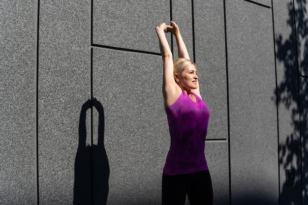 Sport woman doing stretching exercise during outdoor cross\
training workout