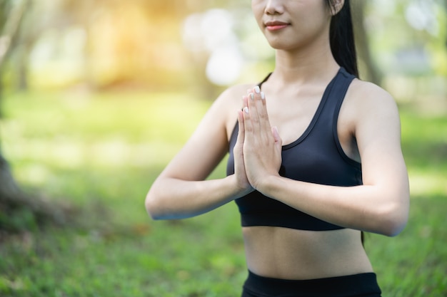 Donna sportiva che fa esercizio di yoga all'aperto nel parco, concetto di yoga sportivo