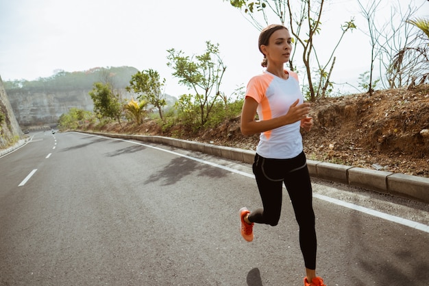 Sport woman running on road side