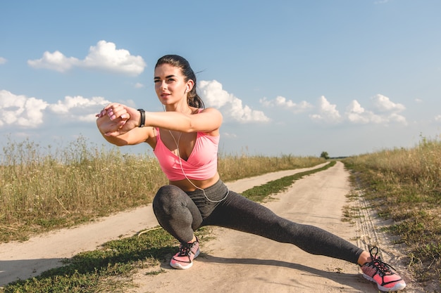 The sport woman stretching the field path