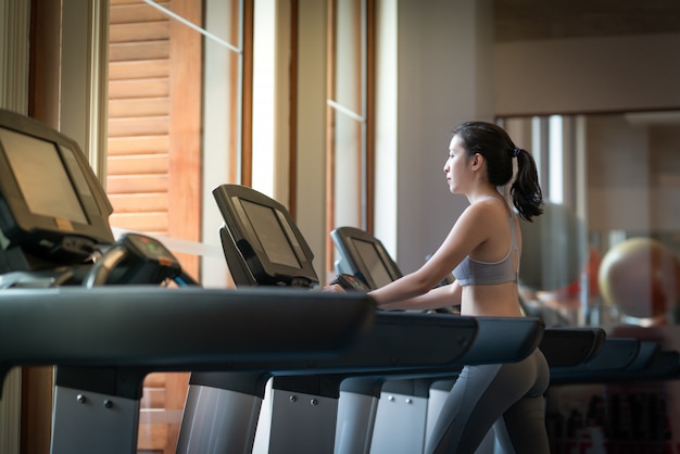 Sport woman walk on cardio machine at the gym