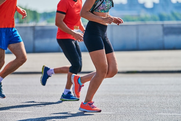 Спортивные женщины бегают в спортивной одежде на городской дороге