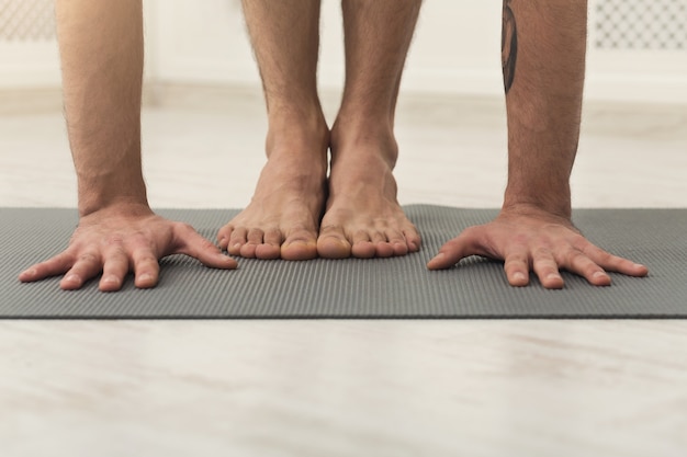 Sport and yoga background. Hands and feet of sportsman doing plank on mat, crop, copy space