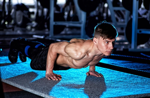 Photo sport young athletic man doing pushups muscular and strong guy exercising