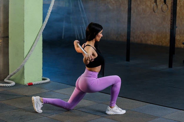 Спорт молодая женщина делает на корточках с штангой в тренажерном зале.
