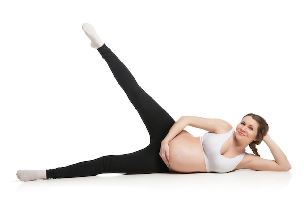 Sport zwangere vrouw doet stretching oefening geïsoleerd op een witte achtergrond