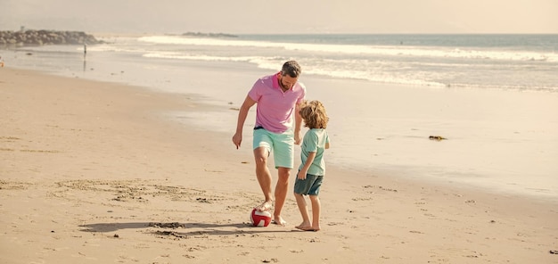 Sportactiviteit blij vader en zoon voetballen op strand papa met jongen op zomerdag