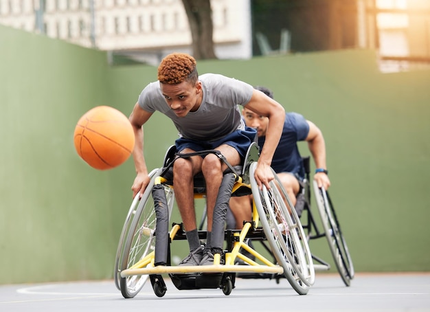 Sportbasketbalspel en mannen in rolstoel in actie voor training en training op buitenbaan Fitnessteam en mannelijke mensen met een handicap en bal voor wedstrijdtraining en games