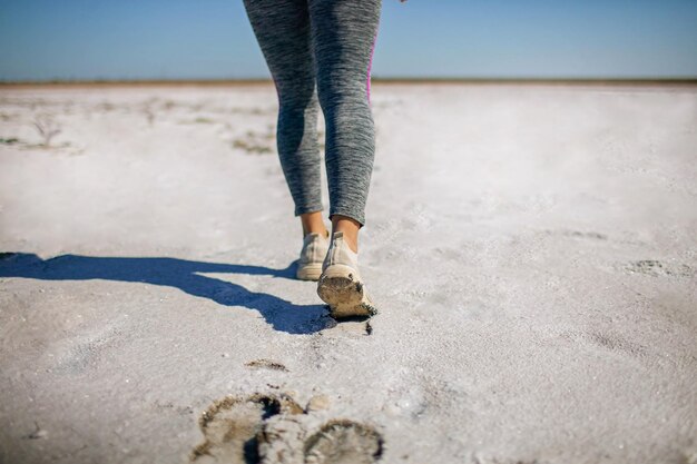 Foto sportbenen lopen op het zandstrand