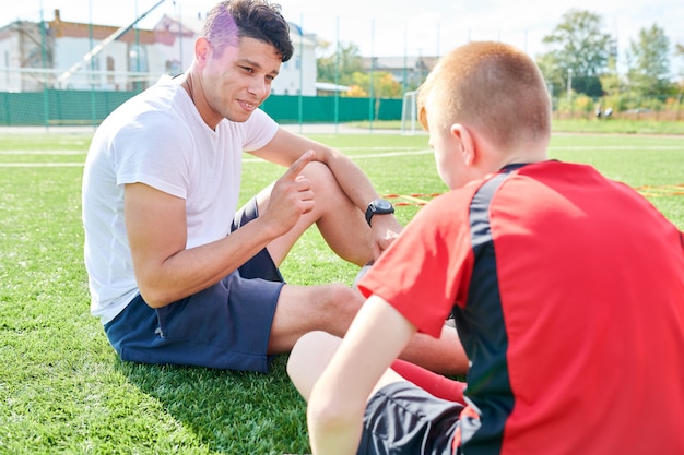 Sportcoach praten met jongen