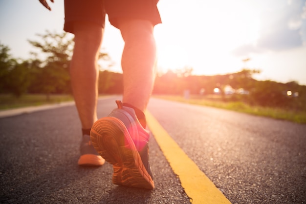 Sporten een mensenbenen die en tijdens zonsondergang lopen lopen.