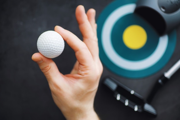 Sporten en een gezonde levensstijl. Minigolf. Witte golfbal en set voor minigolf op tafel. Sportachtergrond met golfconcept.