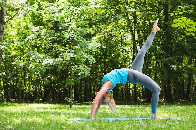 Sportenvrouw die yoga op openlucht doen.