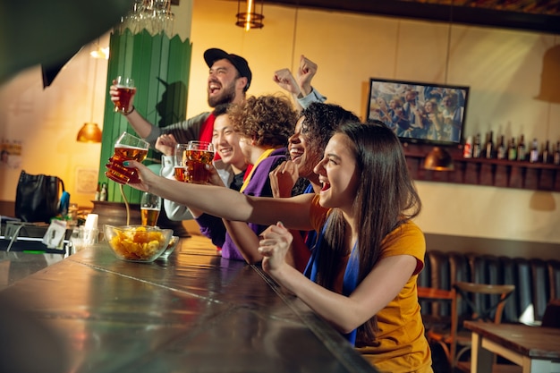 Sportfans juichen bij bar, pub en bier drinken terwijl kampioenschap, competitie aan de gang is