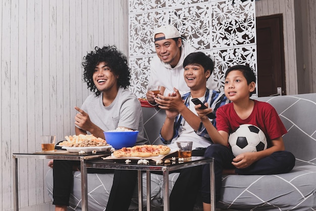 sportfans kijken samen naar een voetbalwedstrijd op televisie in de woonkamer, kinderen bedienen de afstandsbediening