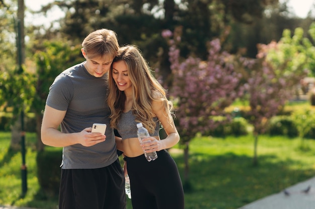 Sportief jong koppel met behulp van mobiele telefoon