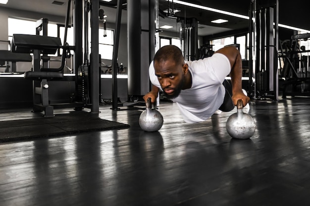 Sportieve Afrikaanse man doet push-up in een sportschool