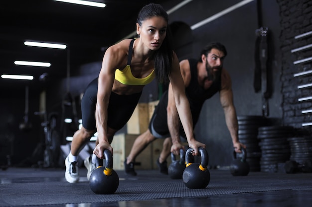 Sportieve Indiase man en vrouw doen push-up in een sportschool.