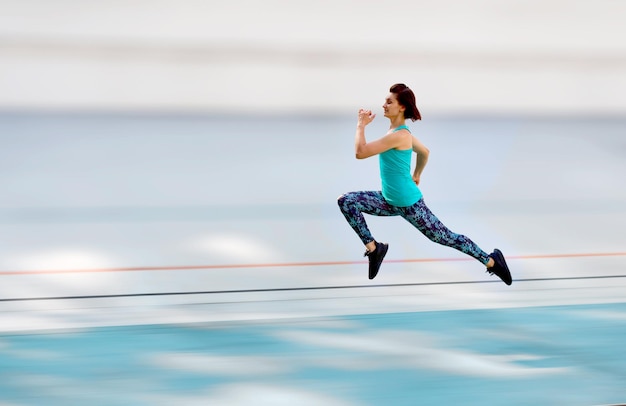 Sportieve jonge vrouw die door het allseason-circuit loopt in het stadsstadion