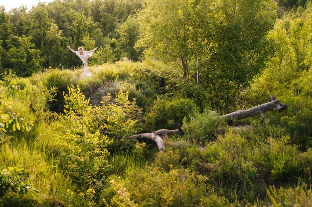 Sportieve jonge vrouw die yoga beoefent, staande in Warrior drie oefening Virabhadrasana III pose Atletische dame die Warrior yoga asana pose buiten de natuur doet Concept van het beoefenen van yoga alleen buiten