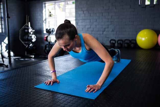 Sportieve jonge vrouw doet push-ups