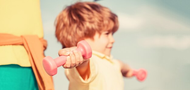 Sportieve jongen met halters. Sport. Fitness, gezondheid en energie. Vrolijke jongen doet oefeningen met halters.