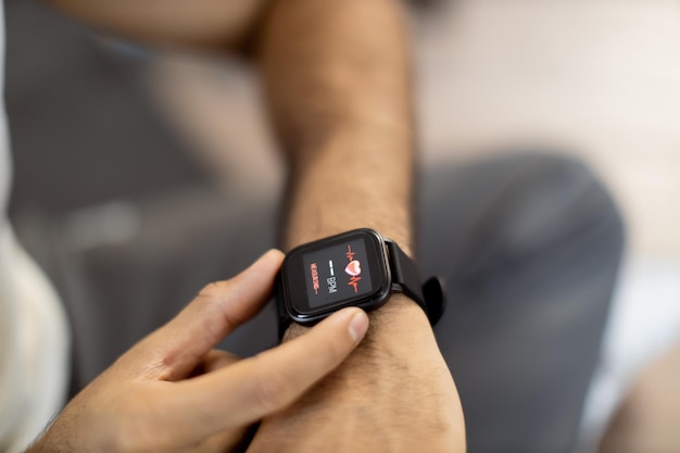 Sportieve man die hartslag op smartwatch controleert na training binnen