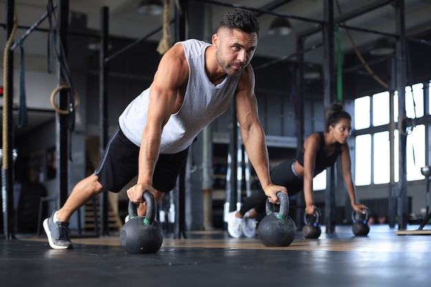 Sportieve man en vrouw doen push-up in een sportschool.