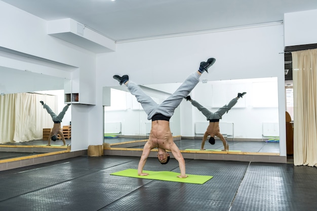 Sportieve man in sportschool staande op handen