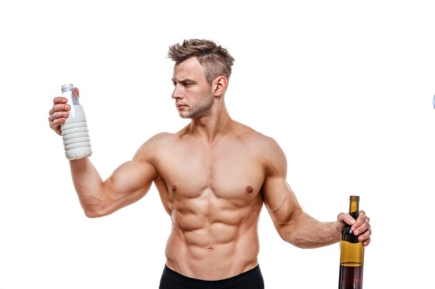 Sportieve man met een wijn en melk en wordt geconfronteerd met een keuze, een gezonde levensstijl of alcohol. Gezondheid, sport, keuze, gezonde voeding en een gezonde levensstijl.