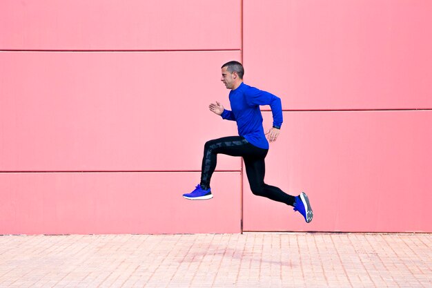 Foto sportieve man oefent op fuchsia muur