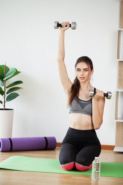 Sportieve mooie vrouw die thuis uitoefent om geschikt te blijven