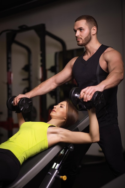 Sportieve sexy man en vrouw met geweldige buikspieren in zwarte sportkleding.