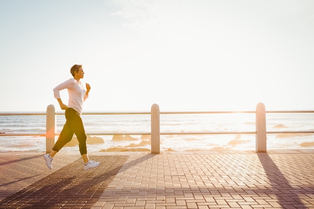 Sportieve vrouw die aan promenade aanstoot