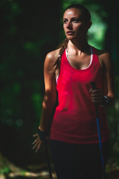 Sportieve vrouw die nordic walking beoefent in het bos