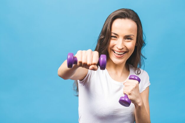 Sportieve vrouw die oefeningen met halters doet