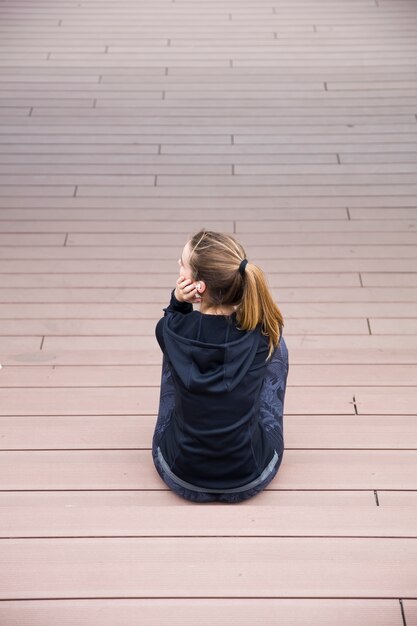 Sportieve vrouw die op de treden in openlucht rust